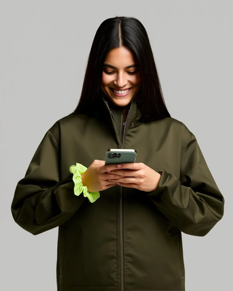 Una ragazza sorride guardando il telefono