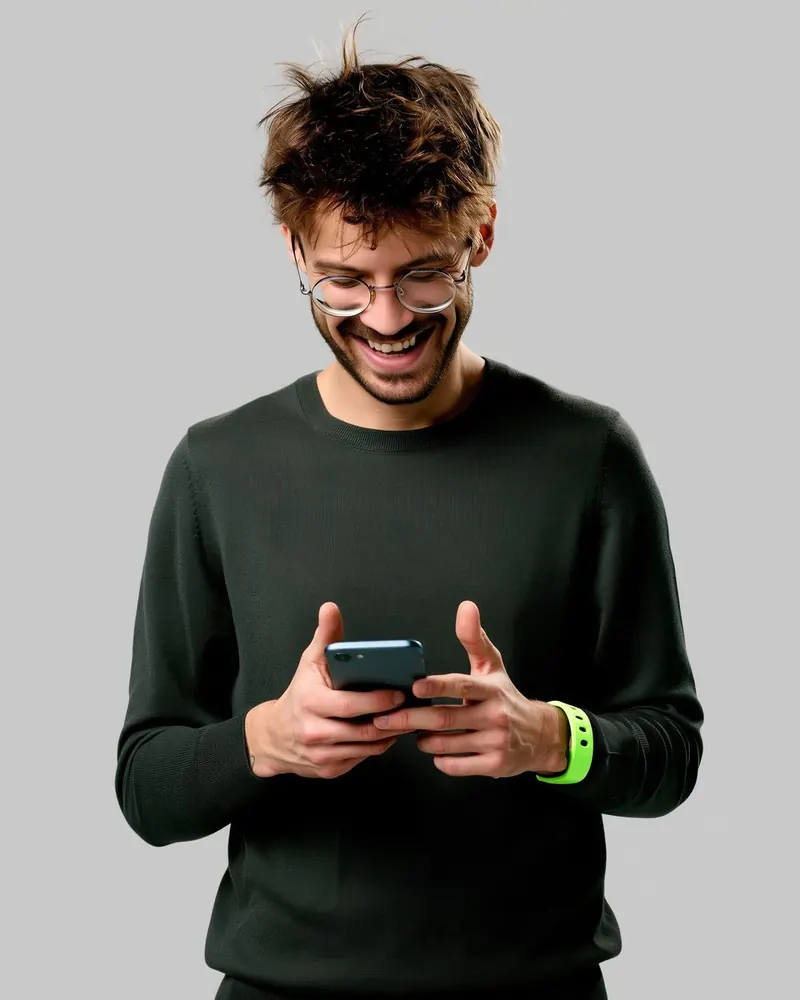 Un ragazzo scrive sul telefono sorridendo