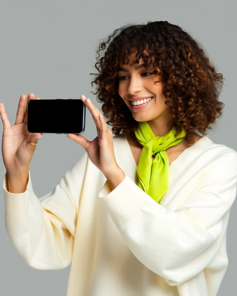 Una ragazza tiene lo smartphone in orizzontale per guardare un video